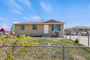 View of front of home featuring a fenced backyard, a front lawn, a playground, and a carport