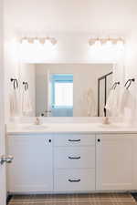 Full bath with a sink, a shower stall, and double vanity
