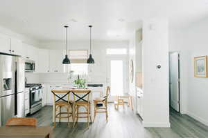 Kitchen featuring backsplash, wood finished floors, and stainless steel appliances