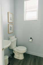 Bathroom with toilet, baseboards, and wood finished floors