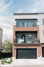 View of front of house with fence, an attached garage, stucco siding, concrete driveway, and a balcony