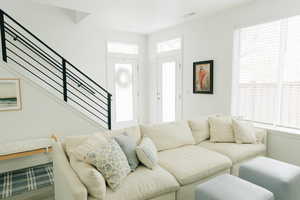 Living area featuring stairs, wood finished floors, and visible vents