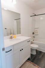 Full bathroom with vanity, shower / tub combo with curtain, wood finished floors, and toilet