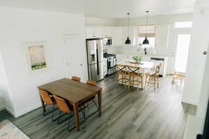 Dining space featuring baseboards and dark wood finished floors
