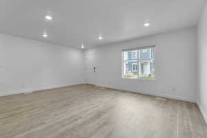 Unfurnished room with recessed lighting, light wood-style flooring, baseboards, and visible vents
