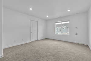 Carpeted empty room featuring baseboards, recessed lighting, and visible vents