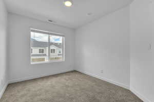 Carpeted spare room with baseboards and visible vents