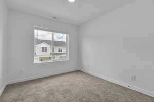 Spare room featuring baseboards, carpet flooring, and visible vents