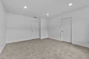Carpeted spare room featuring recessed lighting and baseboards