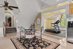 Dining area with ceiling fan with notable chandelier, vaulted ceiling, and recessed lighting