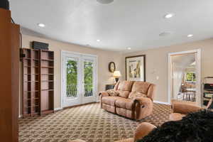 Carpeted living area featuring baseboards, recessed lighting, and a wealth of natural light