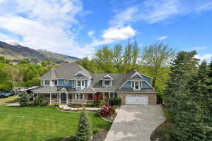View of front of house featuring a porch, driveway, a front lawn, and brick siding