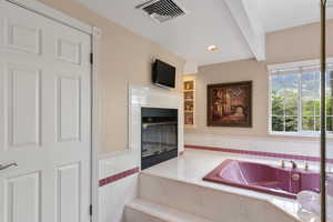 Interior space with visible vents, recessed lighting, a tiled fireplace, and tile counters