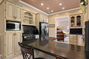 Kitchen featuring stainless steel appliances, recessed lighting, and cream cabinetry