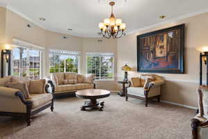 Living area with a wealth of natural light, carpet, a chandelier, and visible vents