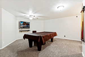 Playroom with billiards, ceiling fan, a textured ceiling, baseboards, and carpet