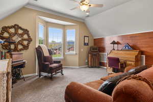 Interior space with visible vents, a ceiling fan, lofted ceiling, and wood walls