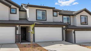 Multi unit property featuring concrete driveway, a garage, and stucco siding