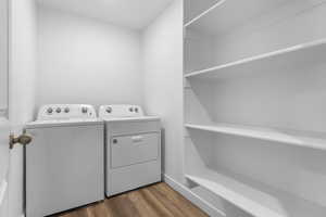 Laundry area featuring laundry area, washing machine and dryer, and dark wood-type flooring