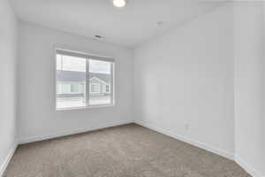 Carpeted empty room featuring baseboards and visible vents