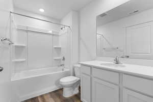 Bathroom with visible vents, bathtub / shower combination, wood finished floors, vanity, and toilet