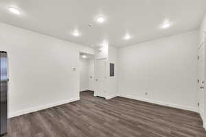 Spare room featuring dark wood finished floors, electric panel, recessed lighting, and a textured ceiling