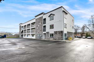 View of apartment building / complex featuring uncovered parking