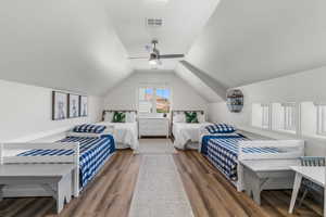 Bedroom with visible vents, a ceiling fan, lofted ceiling, and wood finished floors