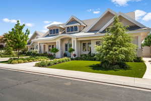 Craftsman-style home with stucco siding, a front yard, and metal roof