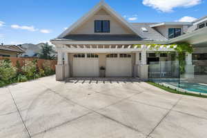 View of front of home featuring fence, a tile roof, and a garage