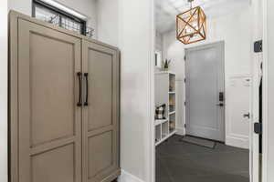 Entrance foyer with an inviting chandelier and dark tile patterned floors