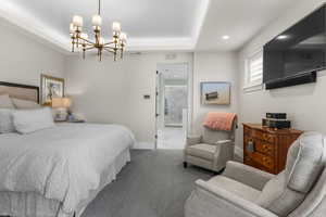 Bedroom featuring baseboards, carpet floors, a notable chandelier, and visible vents