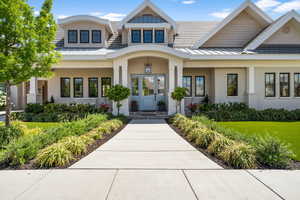 View of exterior entry featuring stucco siding, a standing seam roof, and metal roof