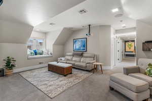 Carpeted living area featuring baseboards and visible vents