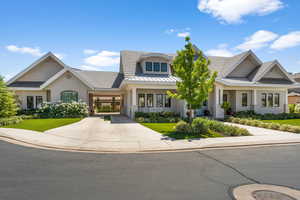 View of front of property featuring a standing seam roof, driveway, a carport, and stucco siding