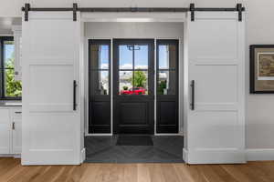 Entryway featuring baseboards, a barn door, and light wood-style floors