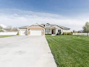Craftsman house featuring fence, a garage, board and batten siding, a front yard, and concrete driveway