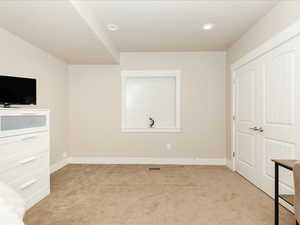Unfurnished bedroom with a closet, visible vents, light carpet, baseboards, and recessed lighting