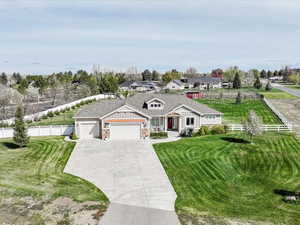 View of front of property featuring a garage, fence, and a front lawn