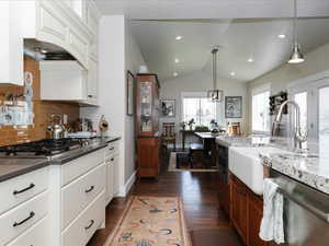 Kitchen featuring white cabinetry, tasteful backsplash, a sink, dark wood finished floors, and stainless steel appliances