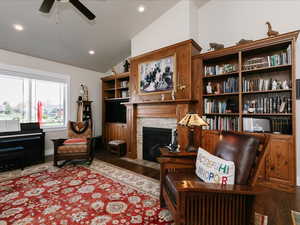 Sitting room featuring a fireplace with flush hearth, wood finished floors, recessed lighting, a ceiling fan, and vaulted ceiling