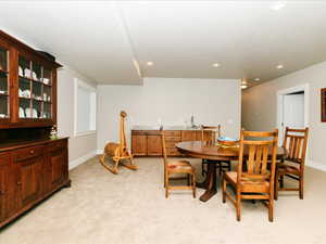 Dining space featuring indoor wet bar, recessed lighting, baseboards, and light carpet