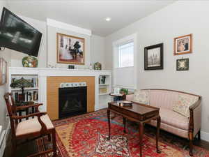Primary Bedroom. Living area featuring recessed lighting, a fireplace with flush hearth, and wood finished floors