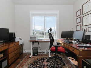 Office area with dark wood-type flooring and baseboards