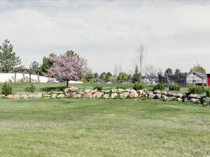 View of home's community with fence and a yard