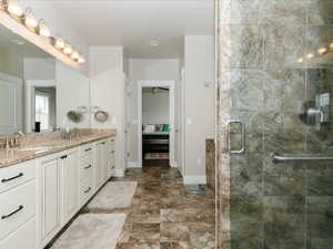 Full bathroom with baseboards, a steam shower, and double vanity