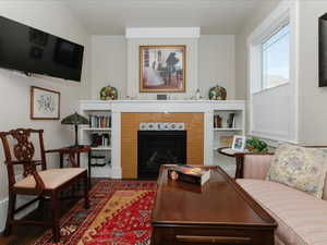 Primary Bedroom, Sitting room, fireplace, featuring wood finished floors, radiator heating unit, and a tile fireplace