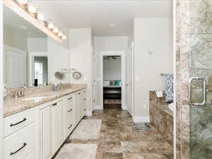 Ensuite bathroom with an enclosed steam  shower, double vanity, a sink, and a garden tub