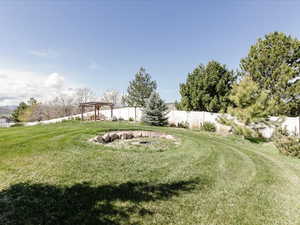 View of yard with fence and a pergola