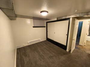 Finished basement featuring carpet floors, baseboards, and baseboard heating